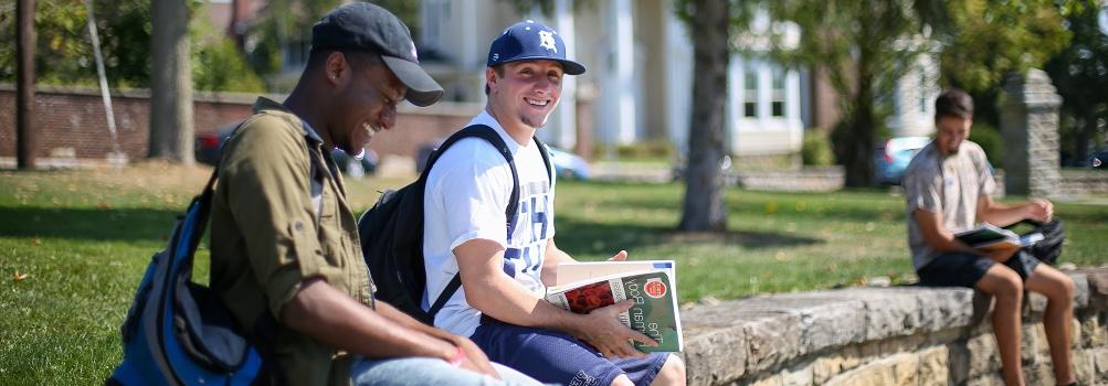 garrett brown and carlos sitting on wall outside smeal building at Penn State DuBois